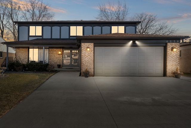 view of front of property featuring concrete driveway, brick siding, and a garage