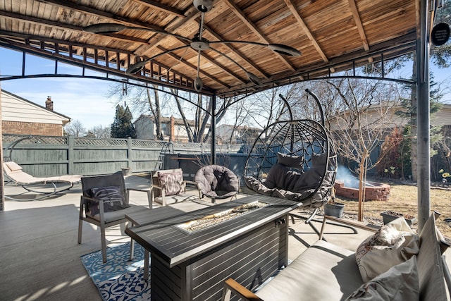 view of patio / terrace with an outdoor living space with a fire pit, a gazebo, and fence