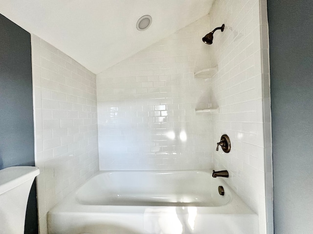 bathroom featuring bathtub / shower combination, vaulted ceiling, and toilet