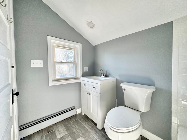 bathroom with vanity, wood finish floors, a baseboard radiator, vaulted ceiling, and toilet