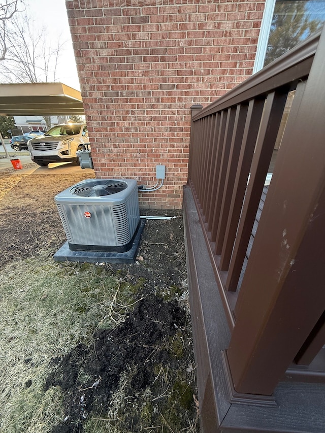 exterior details featuring cooling unit and brick siding