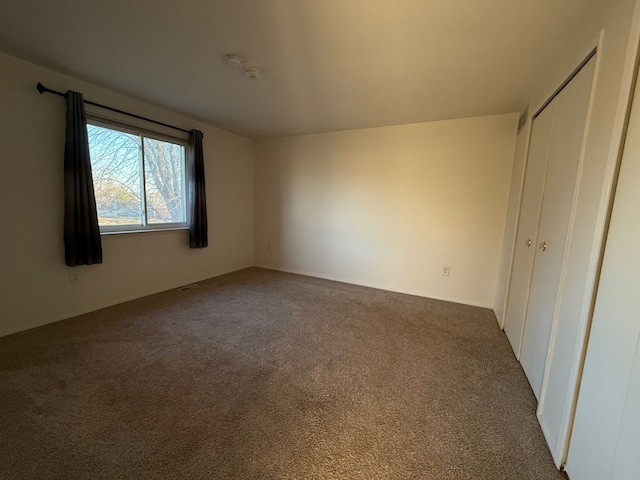 unfurnished bedroom with a closet and carpet floors