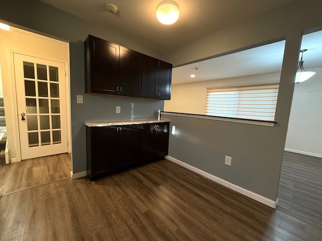 kitchen with light countertops, baseboards, and dark wood-style flooring