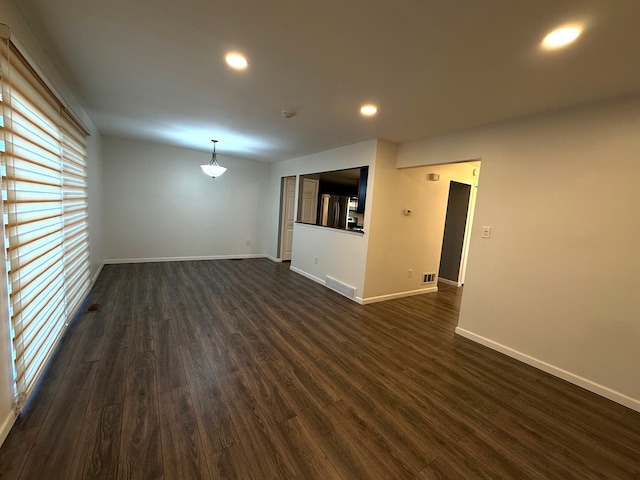 empty room featuring recessed lighting, visible vents, baseboards, and dark wood-style floors