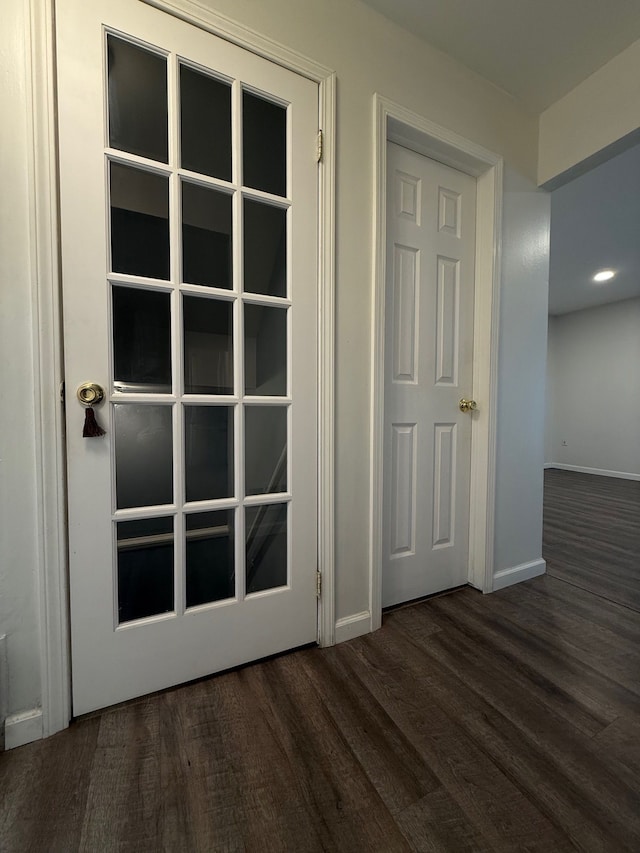 doorway to outside featuring baseboards and wood finished floors