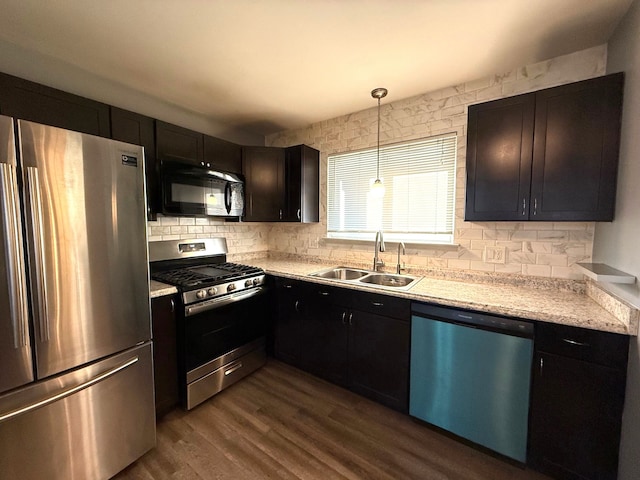 kitchen with a sink, light countertops, decorative backsplash, appliances with stainless steel finishes, and dark wood-style flooring