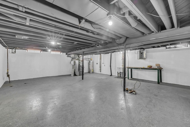 unfinished basement with electric panel and gas water heater