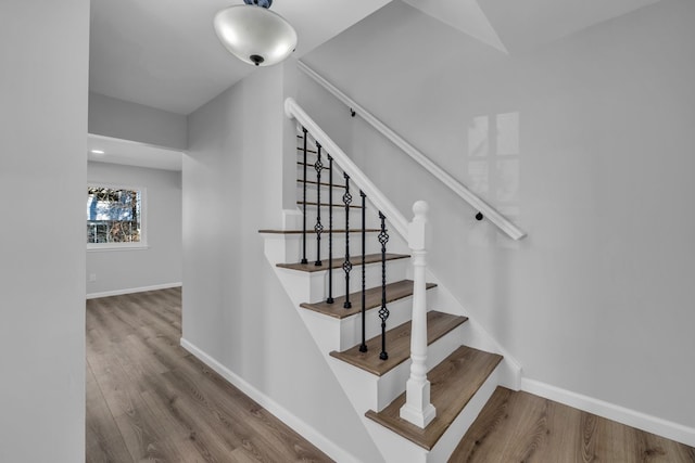 stairway featuring wood finished floors and baseboards