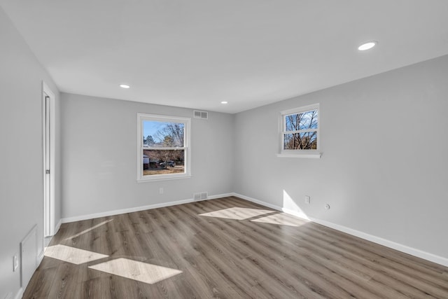 spare room with recessed lighting, baseboards, and wood finished floors