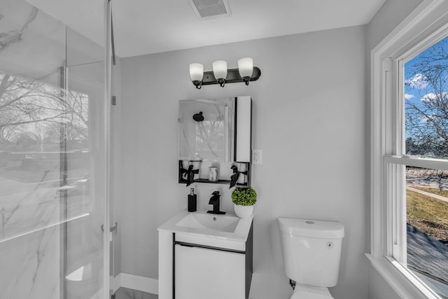 full bathroom with a marble finish shower, visible vents, and toilet