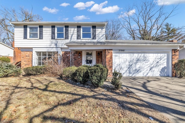 view of front of property featuring concrete driveway, a garage, and brick siding