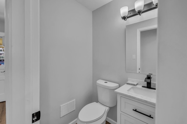 bathroom with visible vents, toilet, and vanity