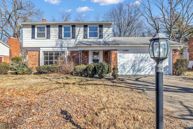 view of front of home with concrete driveway, an attached garage, brick siding, and a chimney