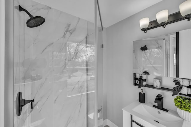 bathroom with a marble finish shower and a sink