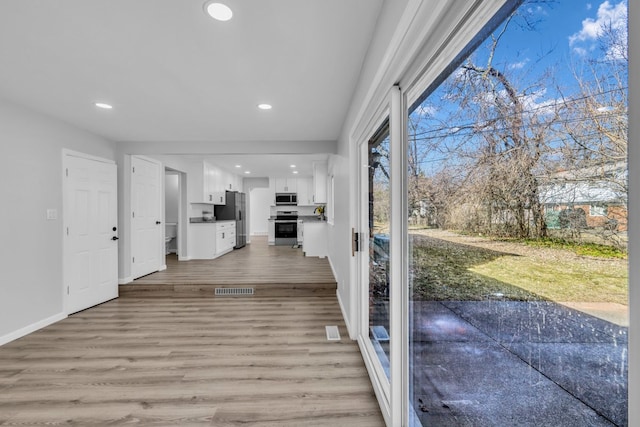 interior space with visible vents, light wood-style flooring, recessed lighting, and baseboards