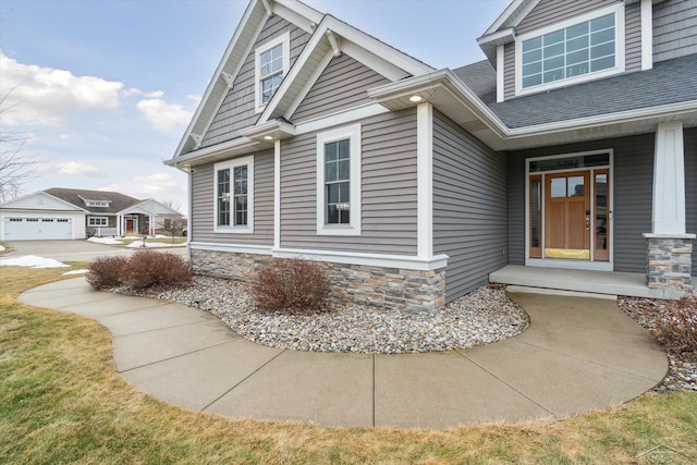 exterior space featuring stone siding and a shingled roof