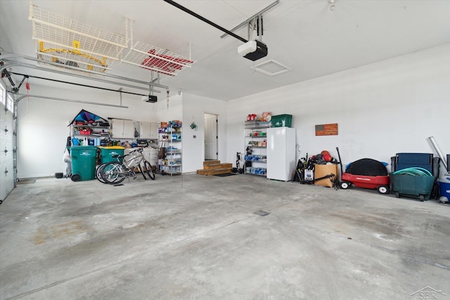 garage featuring freestanding refrigerator and a garage door opener