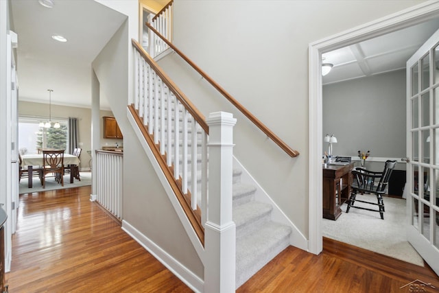 stairs featuring recessed lighting, wood finished floors, baseboards, and a chandelier