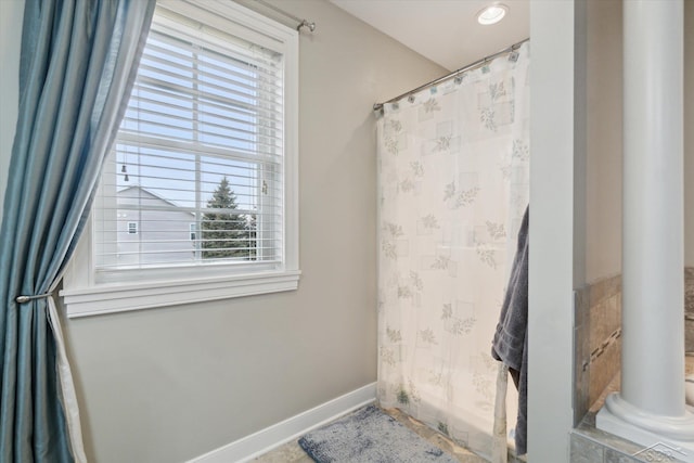 bathroom with a shower with shower curtain, baseboards, and decorative columns