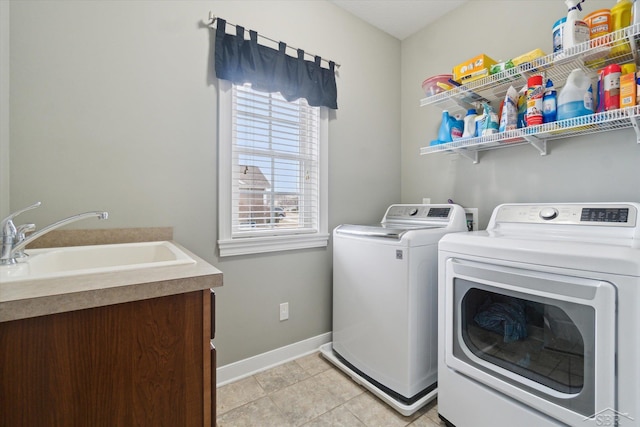 washroom featuring a sink, washing machine and dryer, light tile patterned flooring, baseboards, and laundry area