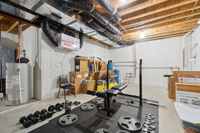 workout area with gas water heater and brick wall