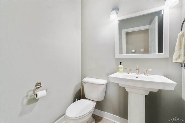 bathroom with a sink, baseboards, and toilet