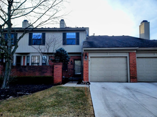 view of front facade featuring brick siding, an attached garage, a chimney, and concrete driveway