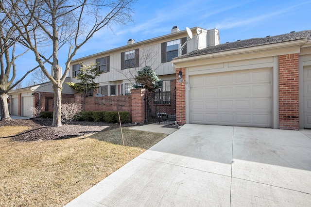 view of front of house with concrete driveway, an attached garage, brick siding, and a chimney