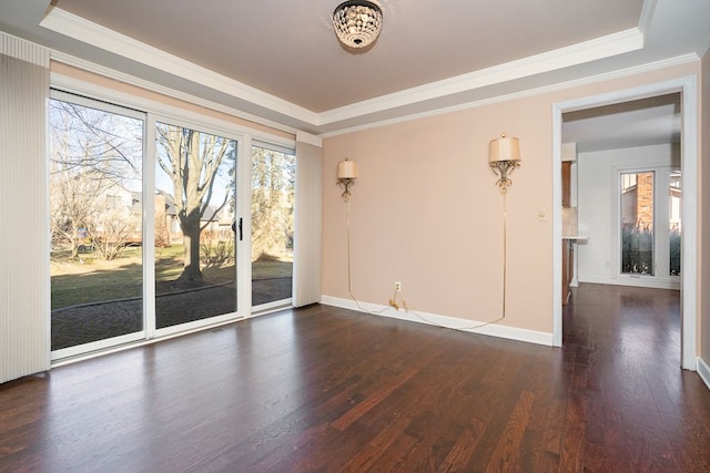 unfurnished room featuring a raised ceiling, crown molding, dark wood-type flooring, and baseboards