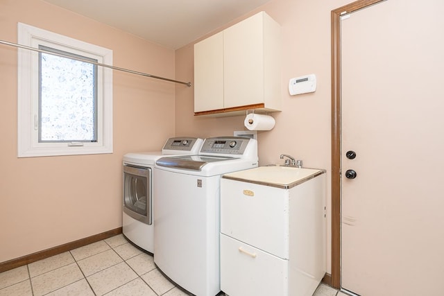 laundry area featuring light tile patterned flooring, cabinet space, washer and dryer, and baseboards