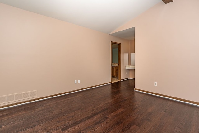 spare room featuring lofted ceiling, baseboards, visible vents, and dark wood-style flooring