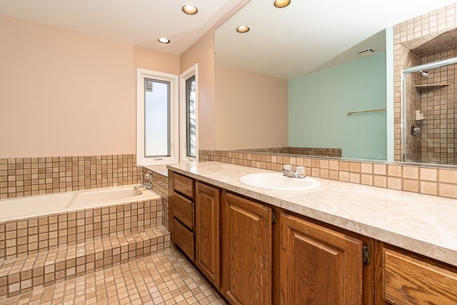 full bath with tile patterned floors, visible vents, tiled shower, a bath, and vanity