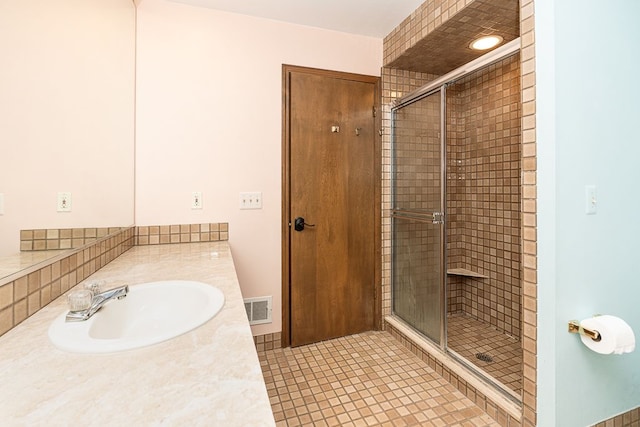 full bath featuring tile patterned floors, visible vents, a stall shower, and vanity