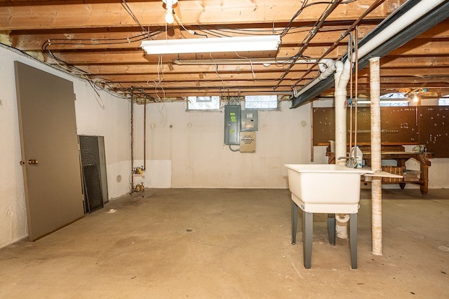 basement featuring electric panel and a sink