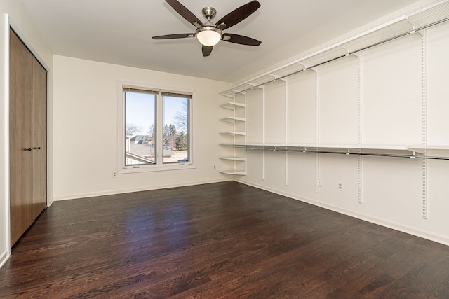 unfurnished living room featuring ceiling fan, baseboards, and dark wood-style floors