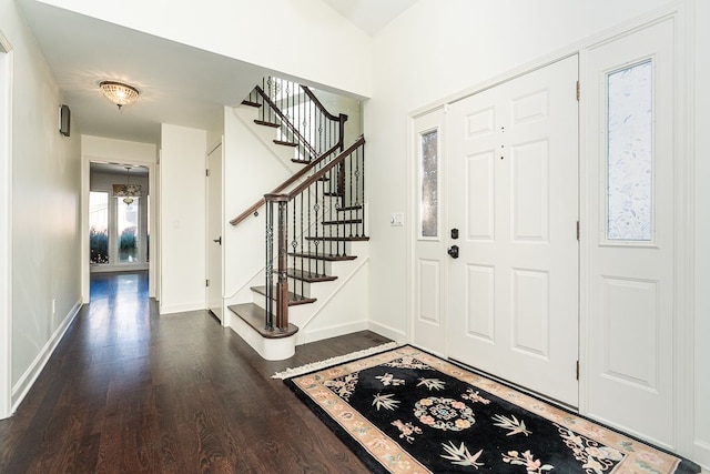 foyer entrance featuring stairs, baseboards, and wood finished floors