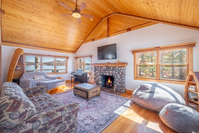 living room featuring a wealth of natural light, wood ceiling, wood finished floors, and a fireplace