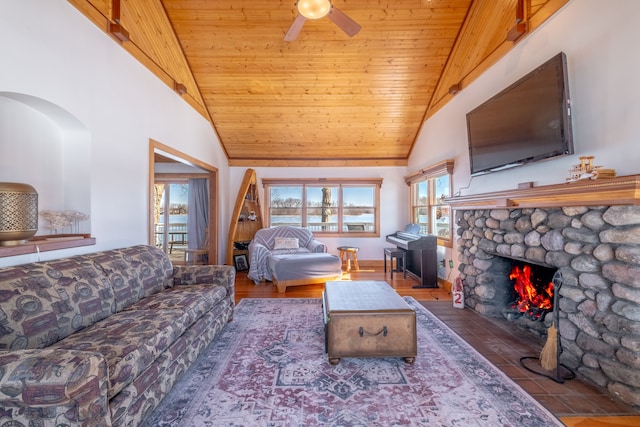 living area featuring ceiling fan, a fireplace, wooden ceiling, wood finished floors, and high vaulted ceiling