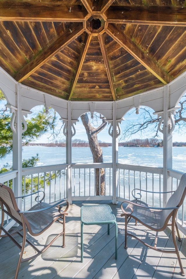 unfurnished sunroom with lofted ceiling, a water view, and wooden ceiling