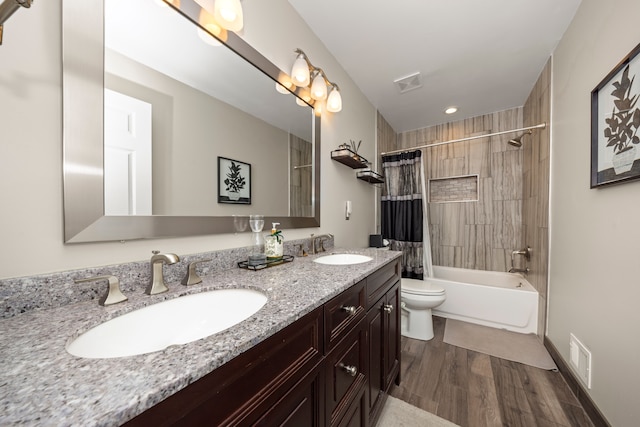 bathroom featuring shower / bath combo with shower curtain, wood finished floors, visible vents, and a sink