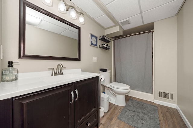 bathroom with visible vents, toilet, a paneled ceiling, and wood finished floors