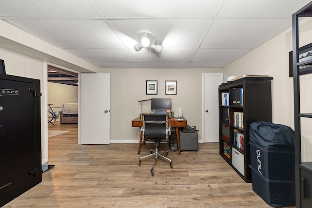 home office with light wood-type flooring and a drop ceiling