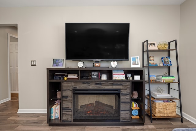 interior details with a fireplace, baseboards, and wood tiled floor