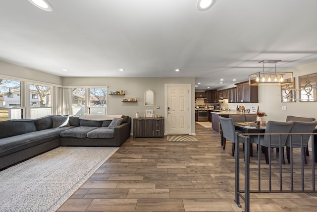 living room featuring recessed lighting, an inviting chandelier, and wood finished floors