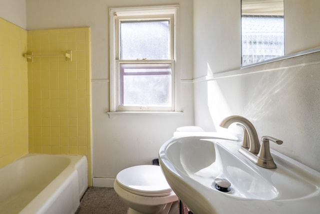 bathroom with toilet, a wealth of natural light, and a sink