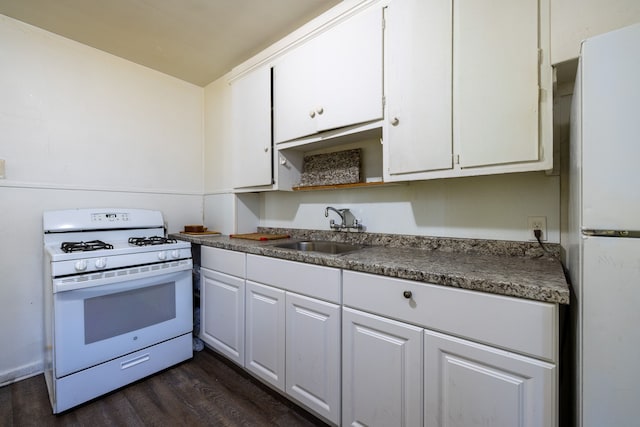 kitchen featuring white appliances, dark wood finished floors, a sink, white cabinetry, and dark countertops