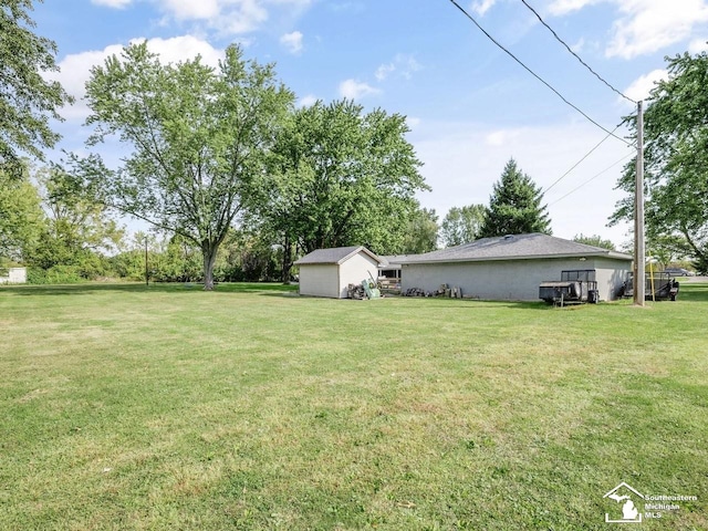 view of yard featuring a storage unit and an outbuilding