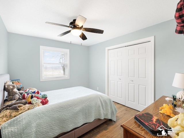 bedroom with a closet, a textured ceiling, wood finished floors, and a ceiling fan