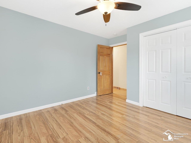 unfurnished bedroom featuring a ceiling fan, visible vents, baseboards, light wood-style flooring, and a closet