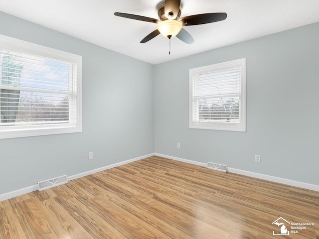 spare room featuring a ceiling fan, baseboards, visible vents, and light wood finished floors